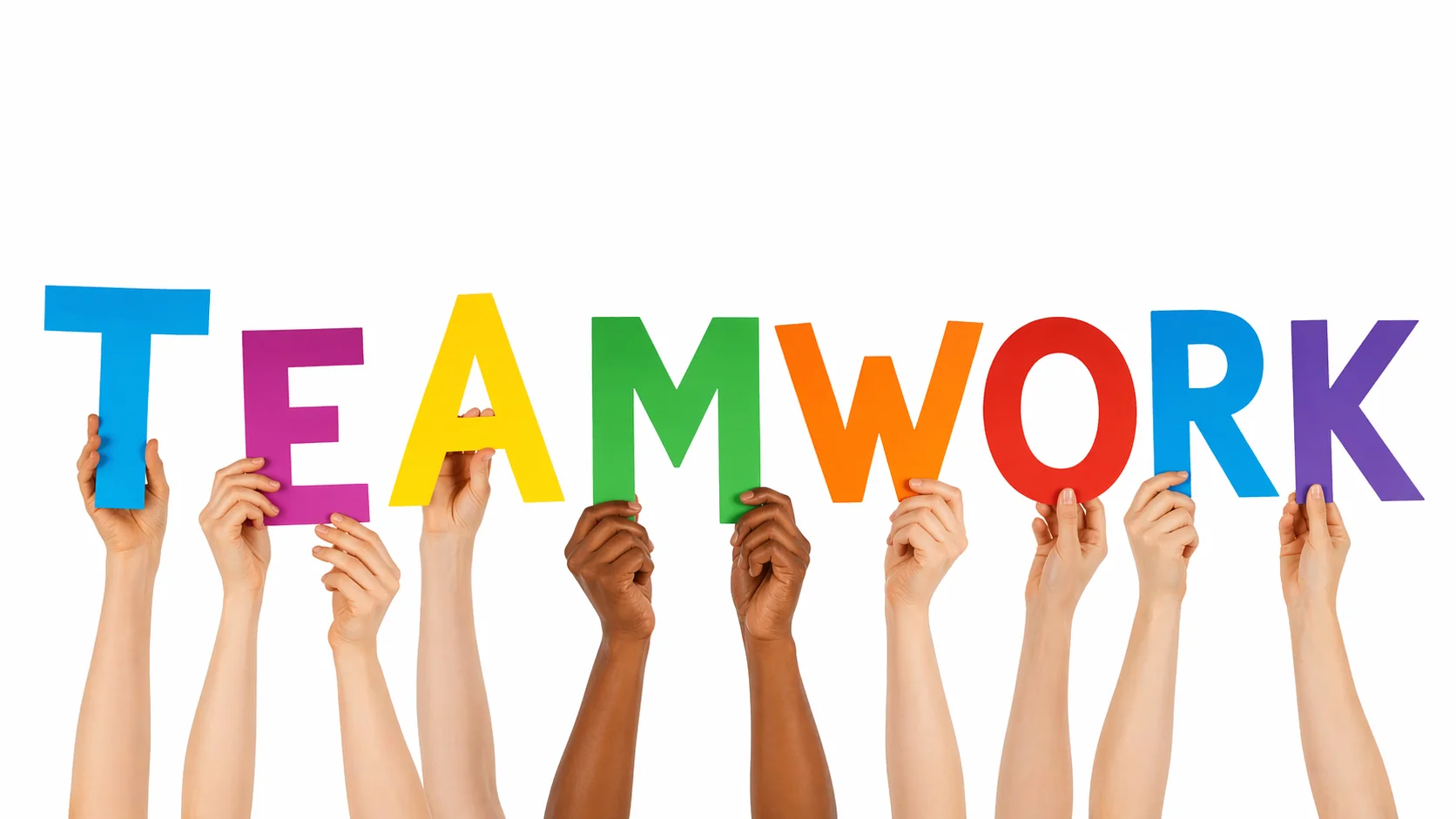 Group of diverse hands holding colorful letters spelling TEAMWORK against a white background.
